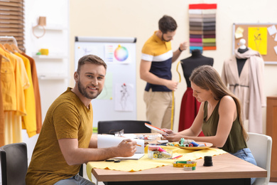 Fashion designers creating new clothes in studio