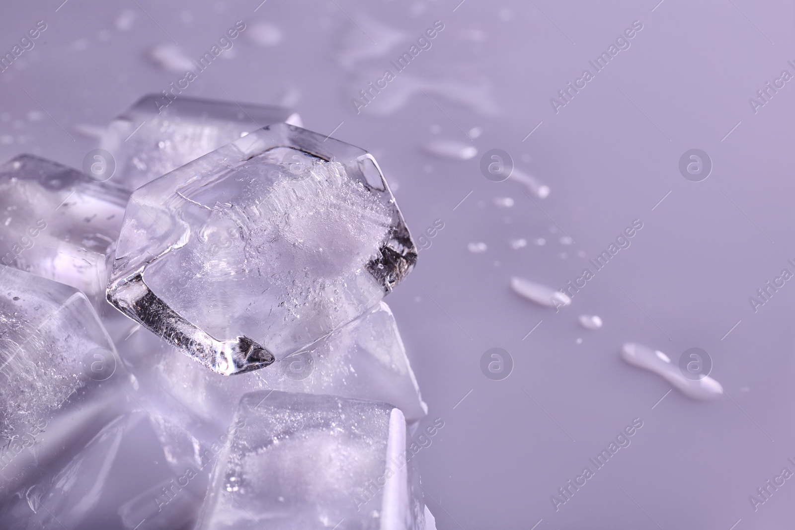 Photo of Transparent ice cubes on color background, closeup. Space for text