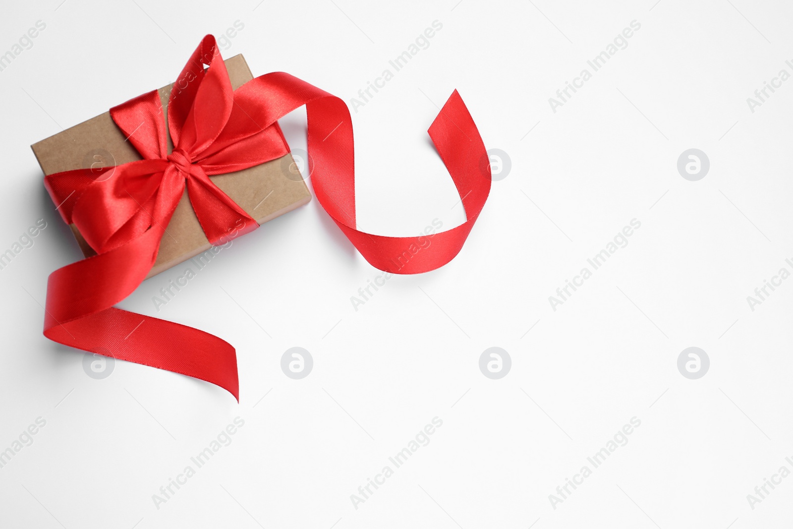 Photo of Beautiful gift box with red bow on white background, top view. Space for text