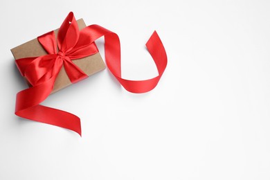 Photo of Beautiful gift box with red bow on white background, top view. Space for text
