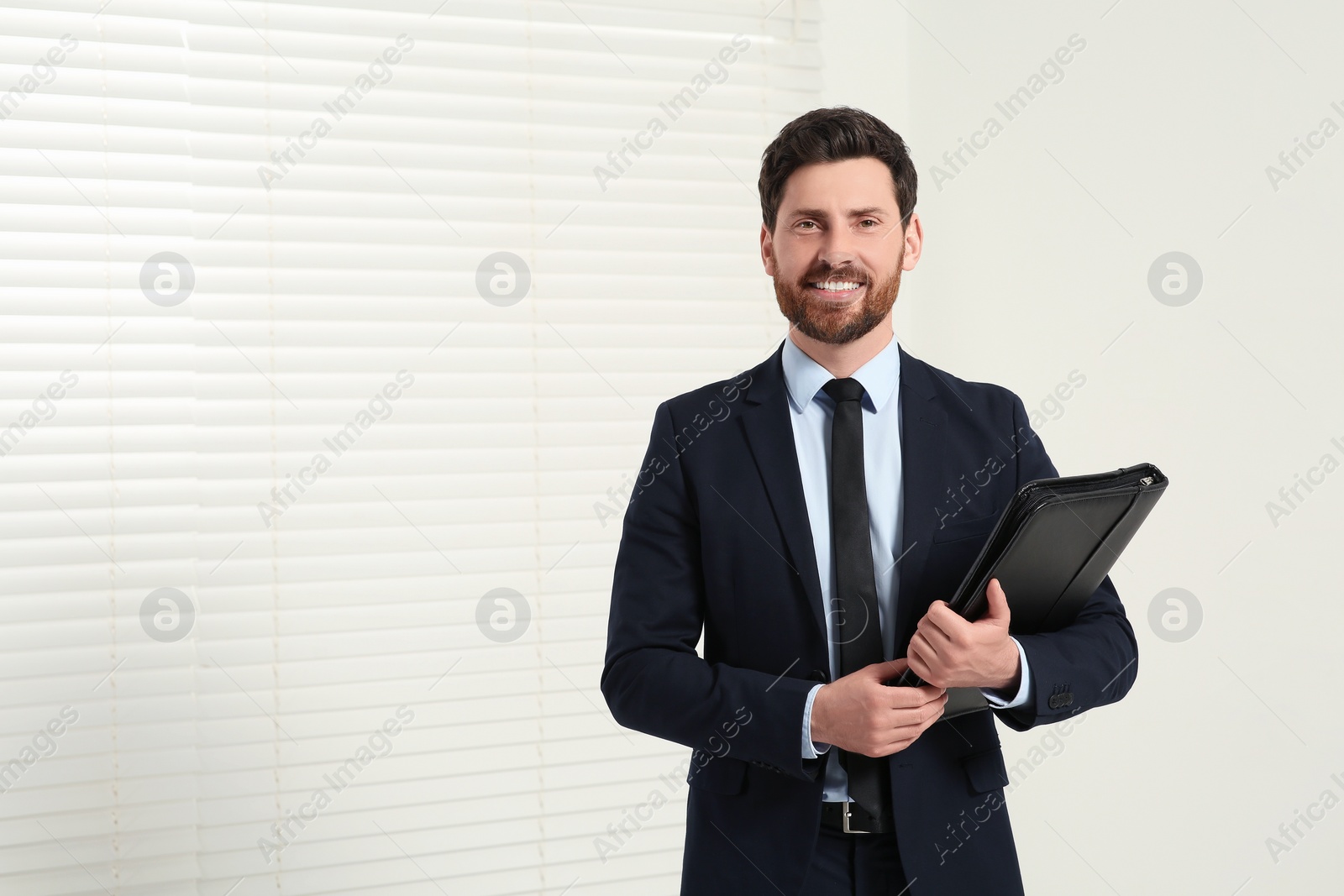 Photo of Handsome real estate agent with documents indoors, space for text