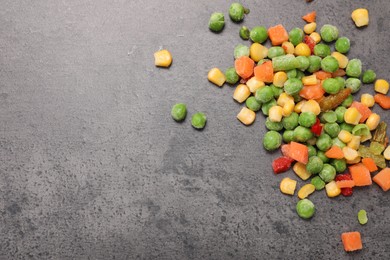 Photo of Mix of different frozen vegetables on grey table, top view. Space for text