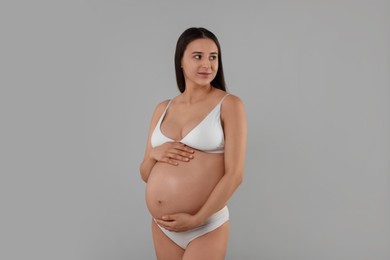 Photo of Beautiful pregnant woman in stylish comfortable underwear on grey background