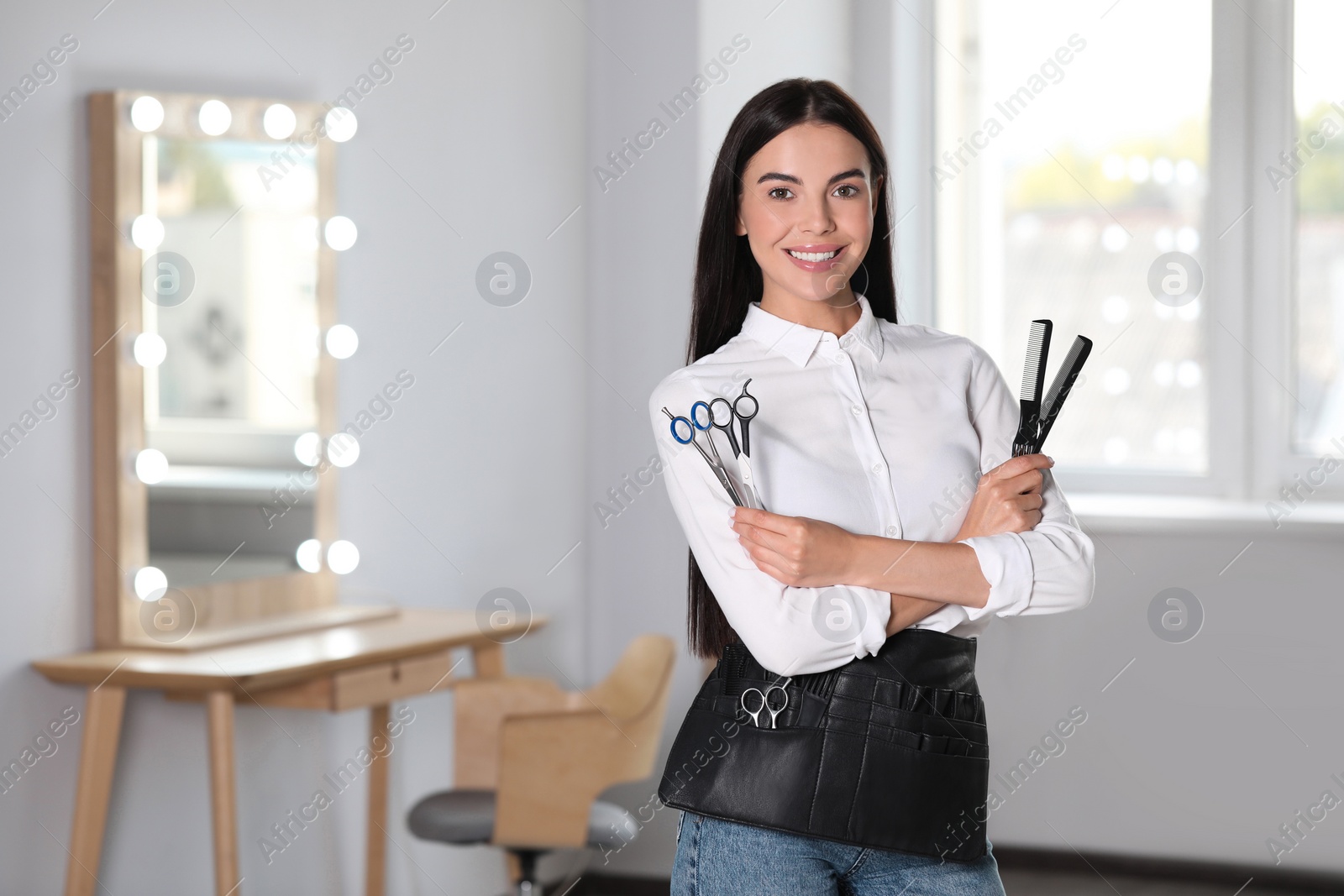 Photo of Portrait of happy hairdresser with professional scissors in beauty salon, space for text
