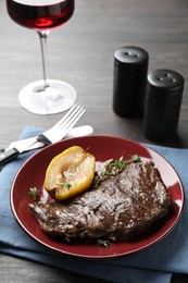 Photo of Delicious roasted beef meat and caramelized pear served on grey wooden table