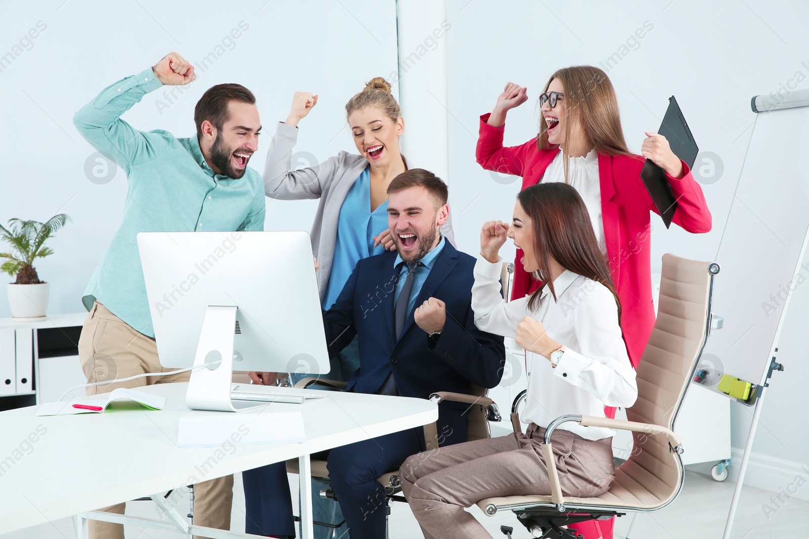 Photo of Group of office employees celebrating victory at workplace