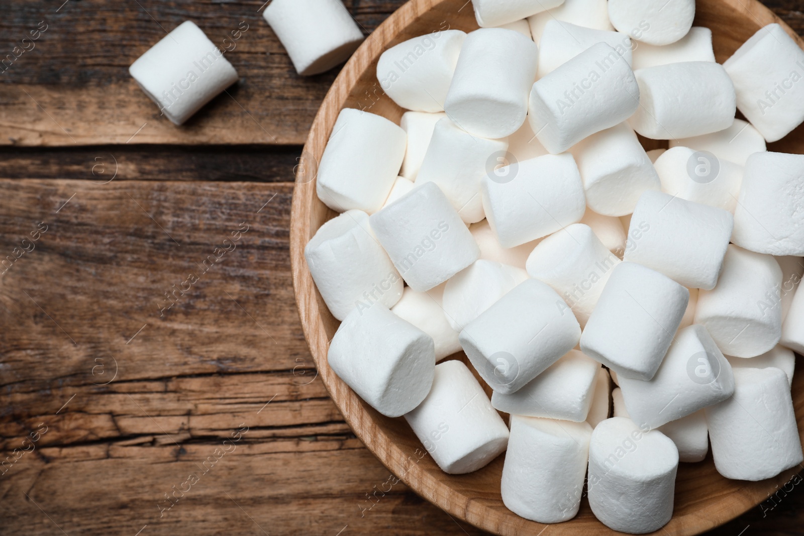 Photo of Delicious puffy marshmallows on wooden table, flat lay
