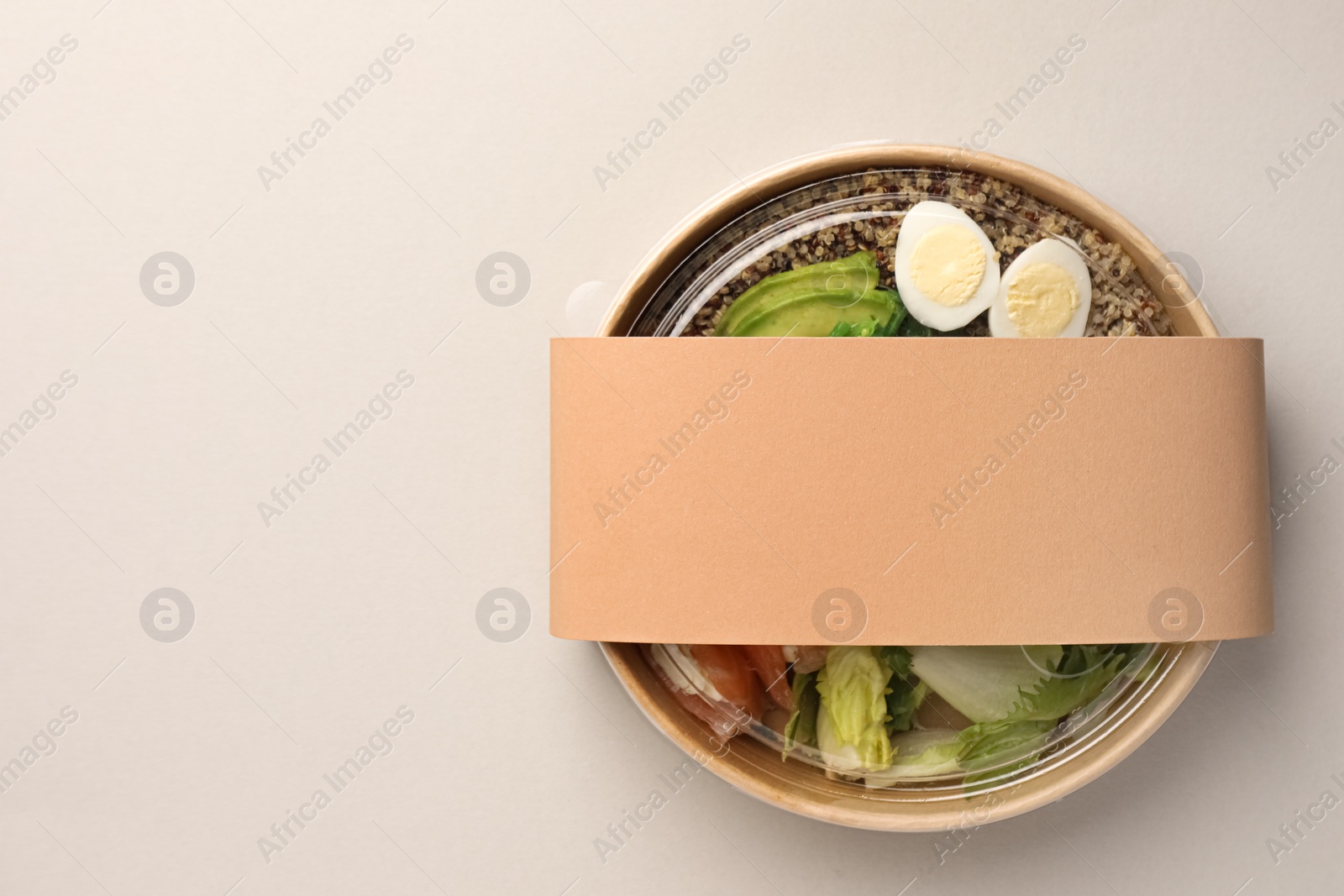 Photo of Tasty food in container on light background, top view. Space for text