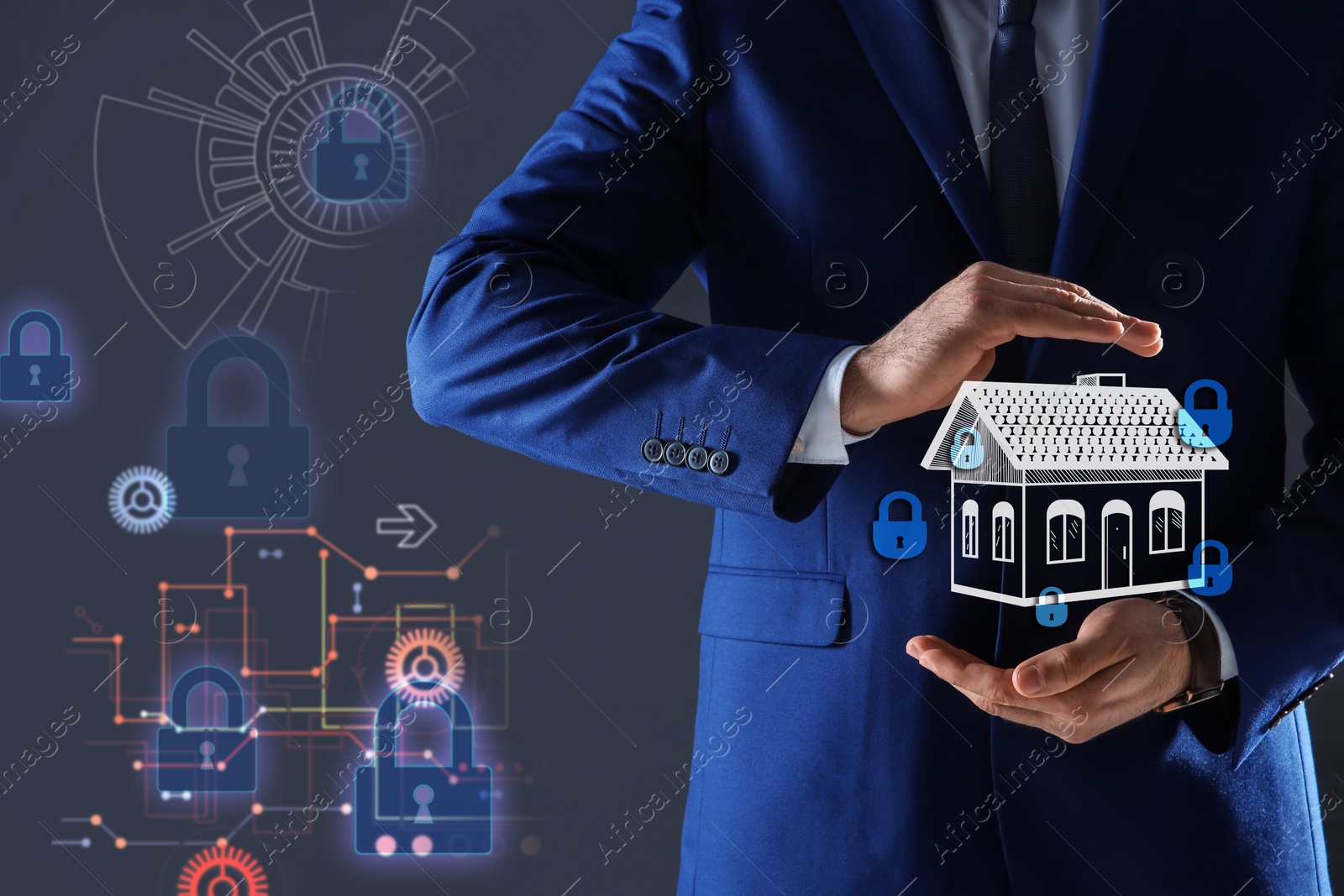 Image of Home security concept. Man holding house on dark background, closeup