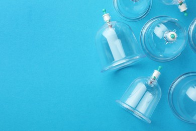 Plastic cups on light blue background, flat lay with space for text. Cupping therapy