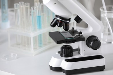 Modern medical microscope on white table in laboratory, closeup. Space for text