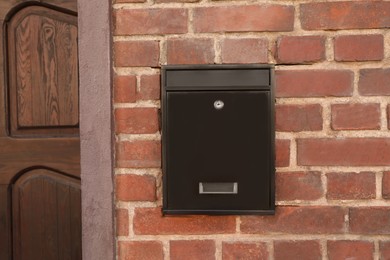 Metal letter box on brick wall outdoors