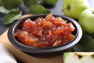 Photo of Bowl of delicious apple jam and fresh fruits on table, closeup