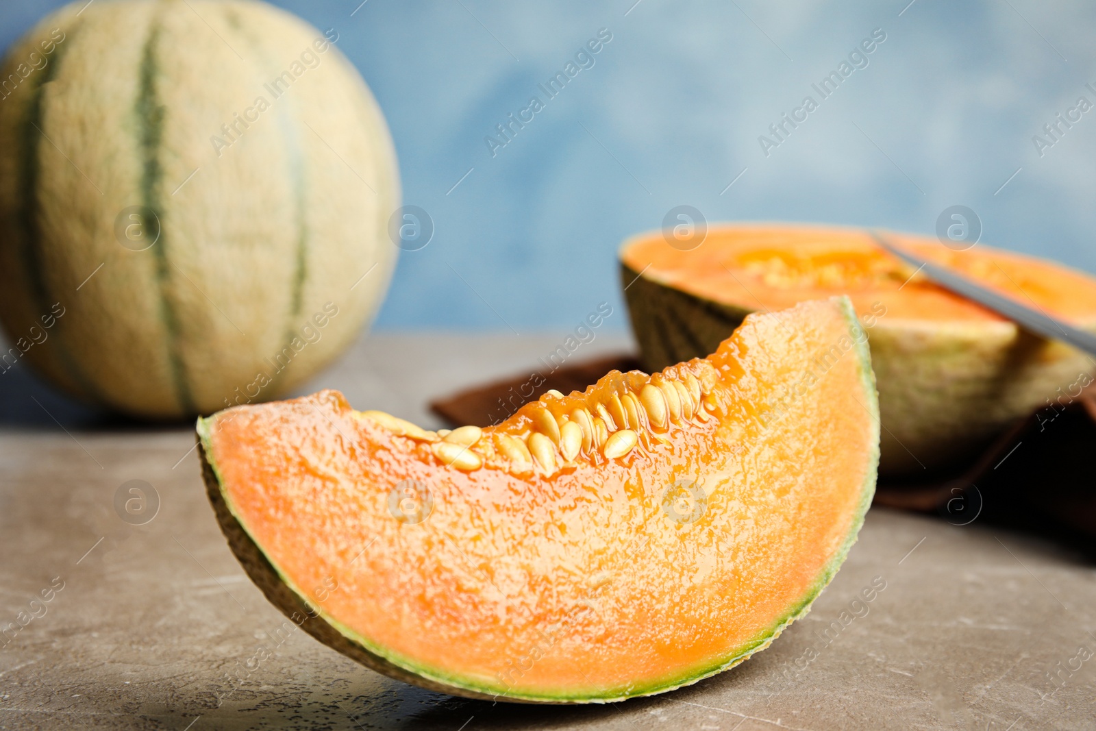 Photo of Slice of ripe cantaloupe melon on beige marble table