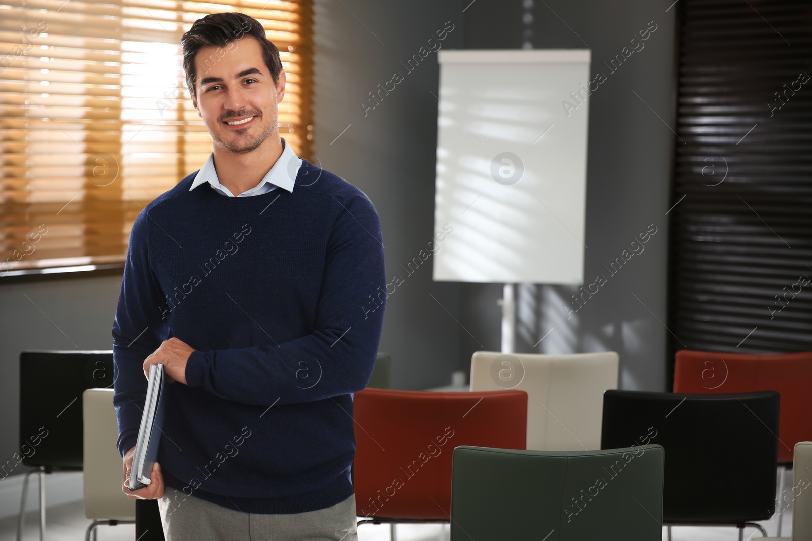 Image of Young teacher waiting for students in classroom