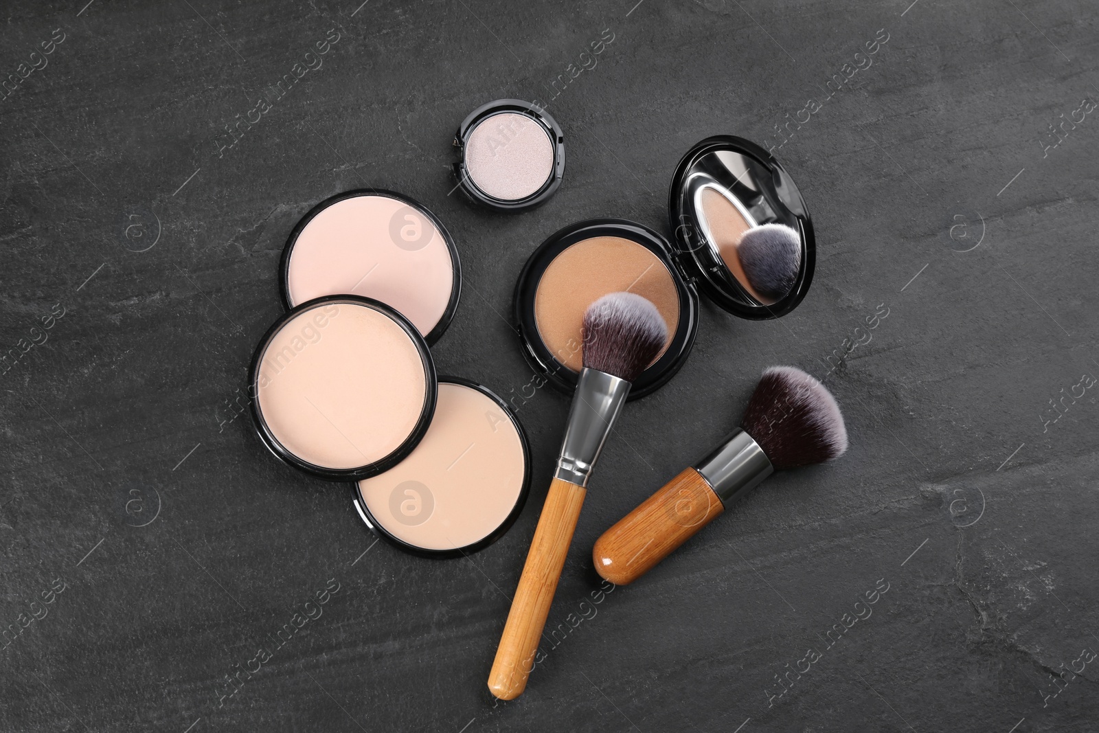 Photo of Flat lay composition with makeup brushes on black stone table