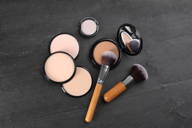 Flat lay composition with makeup brushes on black stone table