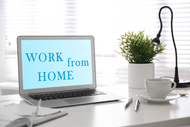 Image of Modern laptop with text WORK FROM HOME on office table