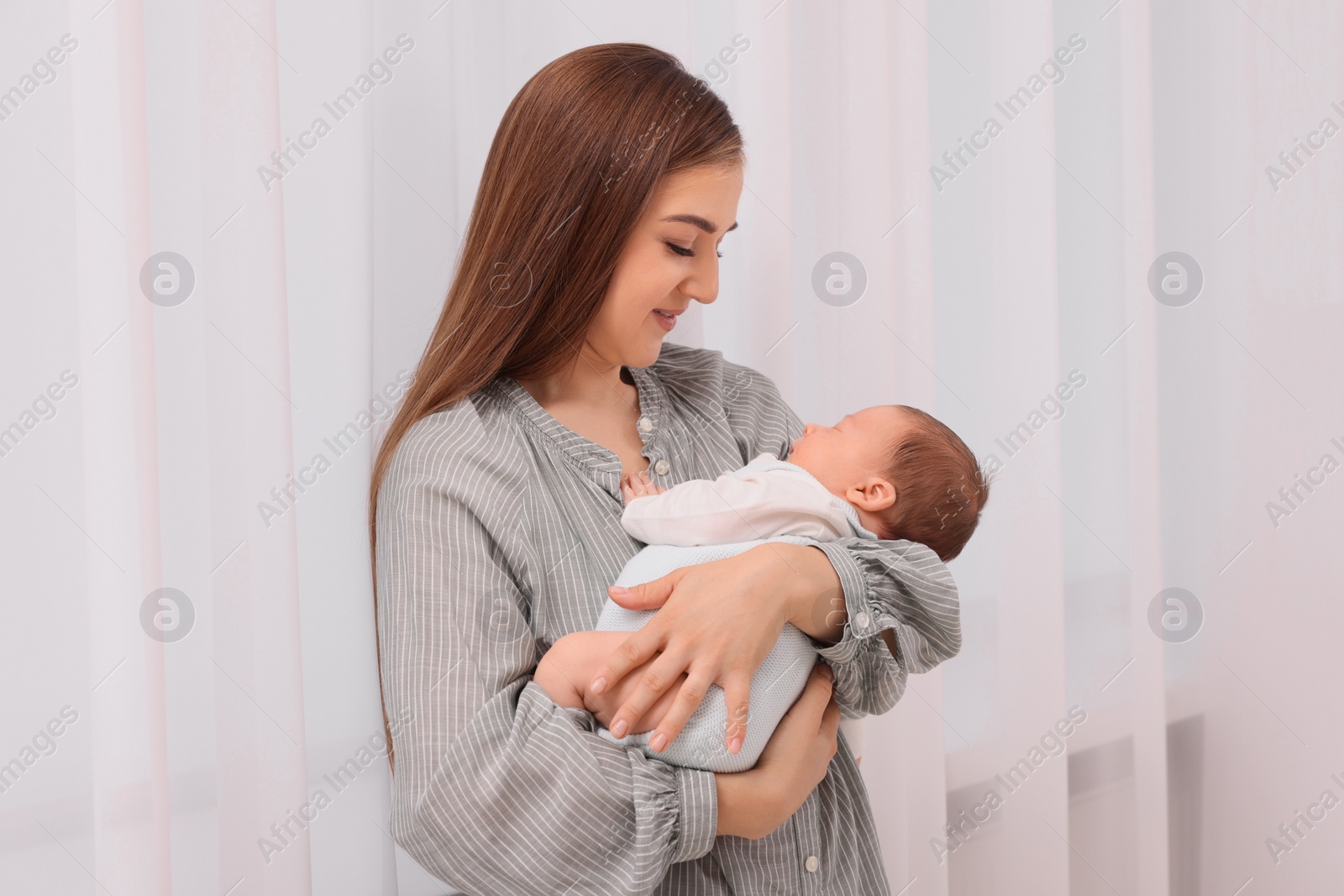 Photo of Mother with her cute newborn baby indoors