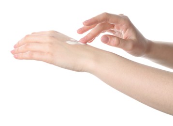 Woman applying cream on her hand against white background, closeup