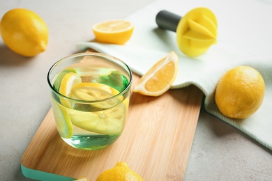 Photo of Glass of water with lemon slice on wooden board