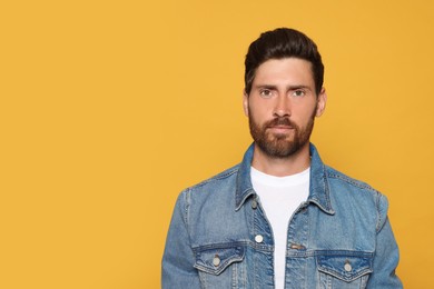 Photo of Portrait of bearded man on orange background. Space for text
