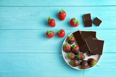 Photo of Flat lay composition with chocolate covered strawberries on wooden background