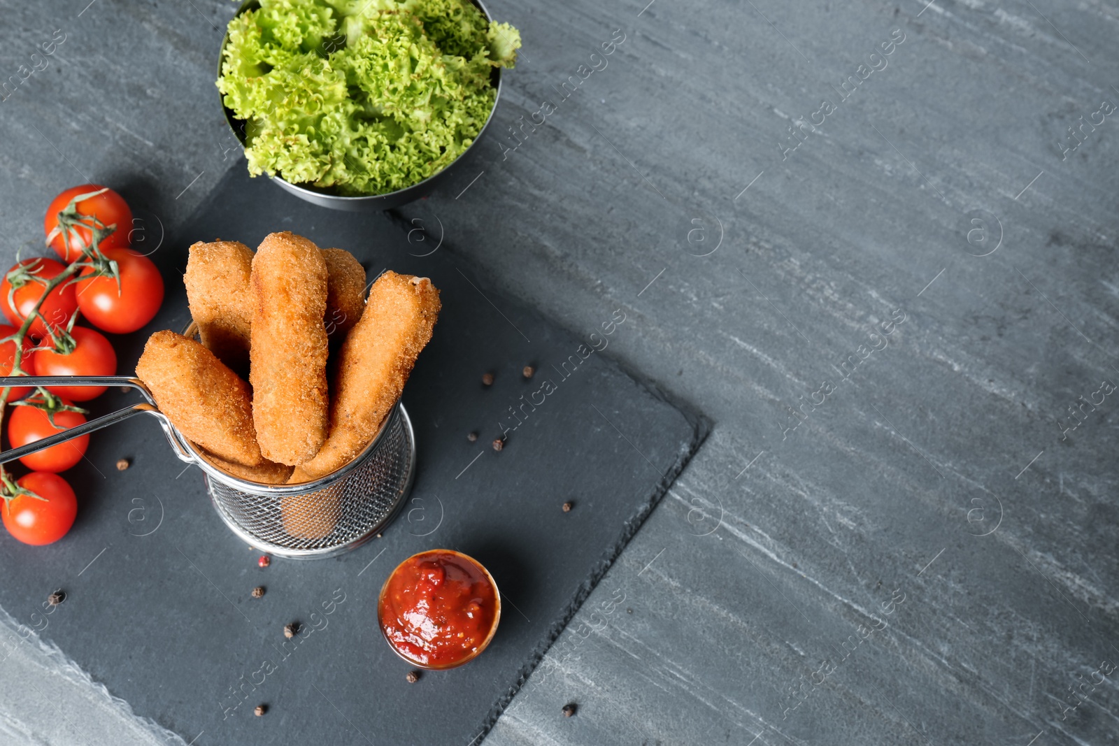 Photo of Basket of cheese sticks and sauce on table. Space for text