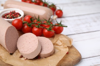 Delicious liver sausages and other products on white wooden table, closeup. Space for text