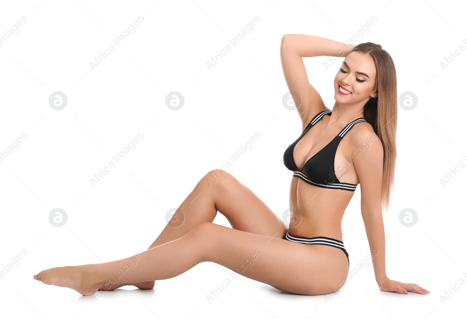 Photo of Pretty sexy woman with beautiful slim body in stylish bikini sitting on white background