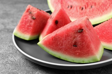 Photo of Delicious fresh watermelon slices on grey table, closeup