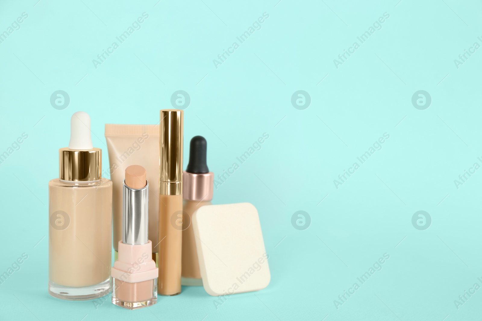 Photo of Foundation makeup products on turquoise background, space for text. Decorative cosmetics