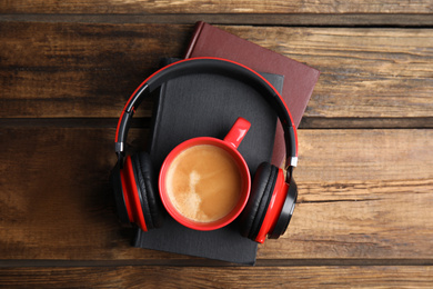 Photo of Books, coffee and headphones on wooden table, top view