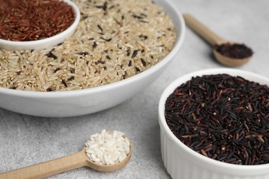 Photo of Different sorts of rice on grey table, closeup