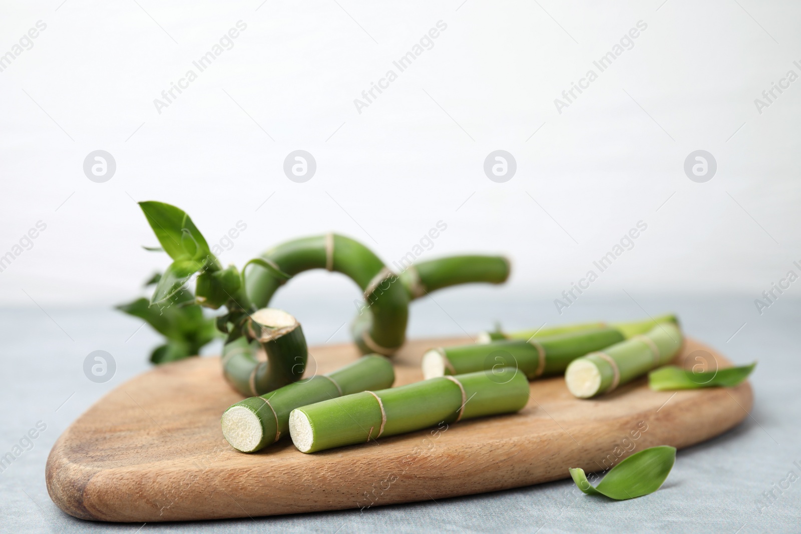 Photo of Pieces of beautiful green bamboo stems on wooden board, closeup