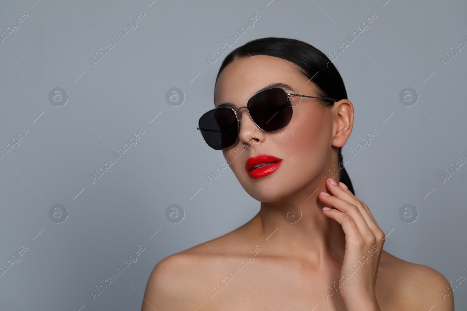 Photo of Attractive woman in fashionable sunglasses against grey background. Space for text