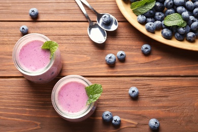 Photo of Flat lay composition with blueberry smoothie on wooden table