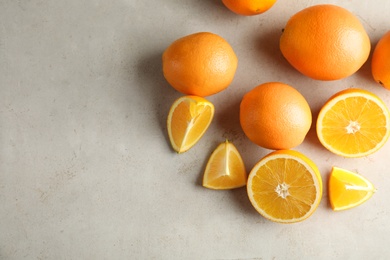 Photo of Flat lay composition with fresh oranges on grey table. Space for text