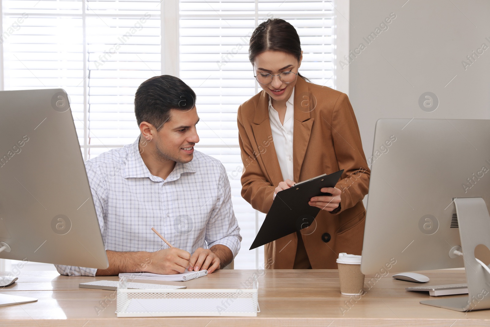 Photo of Businesswoman helping intern with work in office