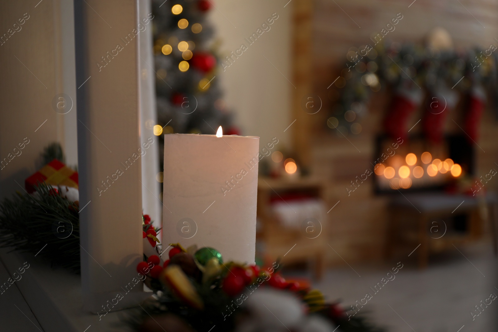 Photo of Burning candle in stylish Christmas room interior. Space for text