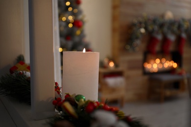 Burning candle in stylish Christmas room interior. Space for text