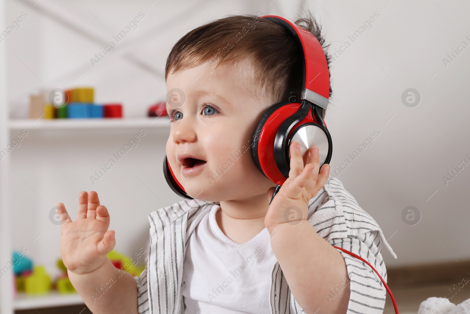 Photo of Cute little boy in headphones listening to music at home