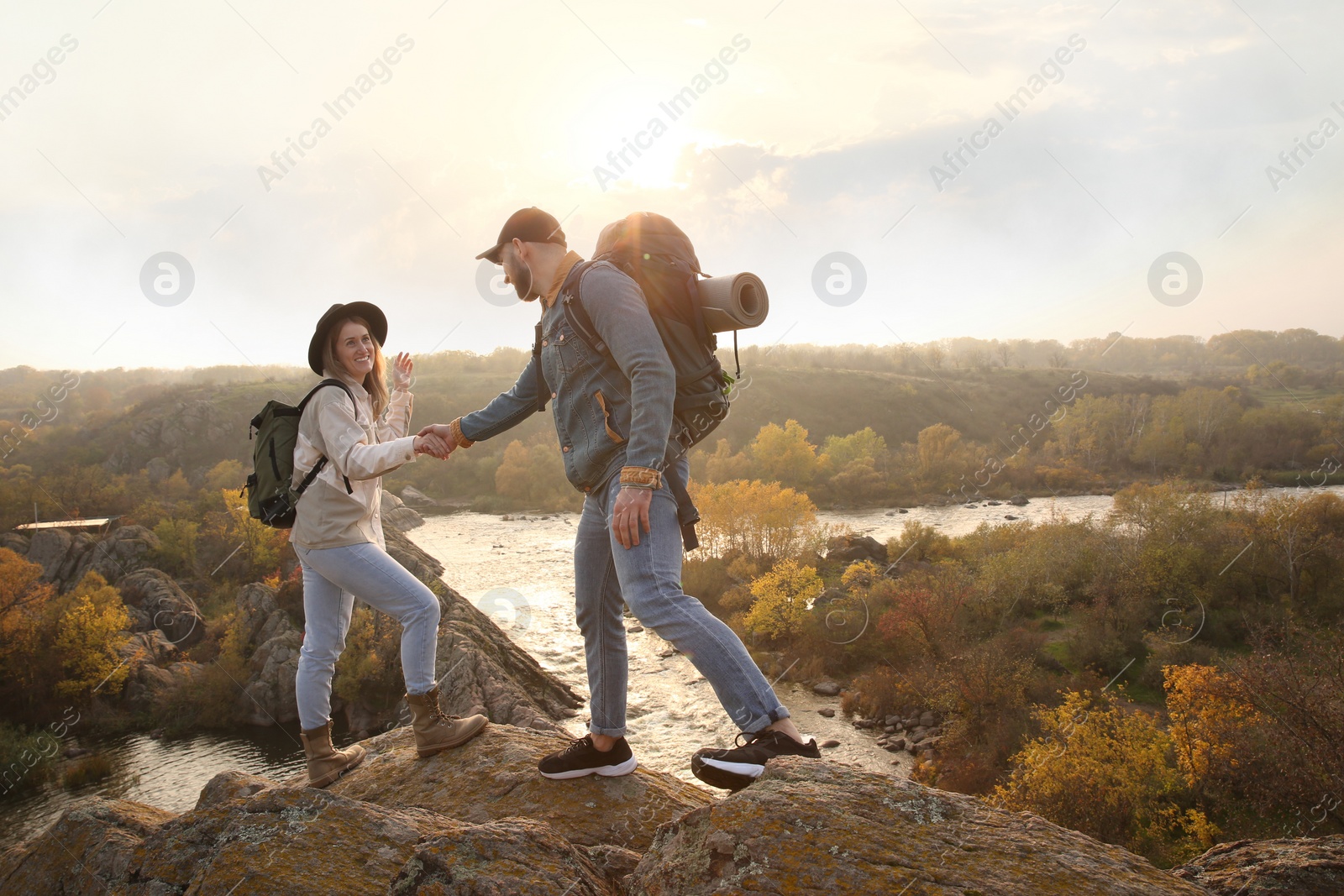 Photo of Couple of hikers with backpacks climbing up mountains