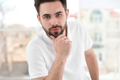 Portrait of handsome man in light room, closeup