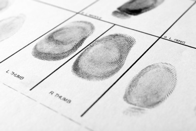 Police form with fingerprints, closeup. Forensic examination