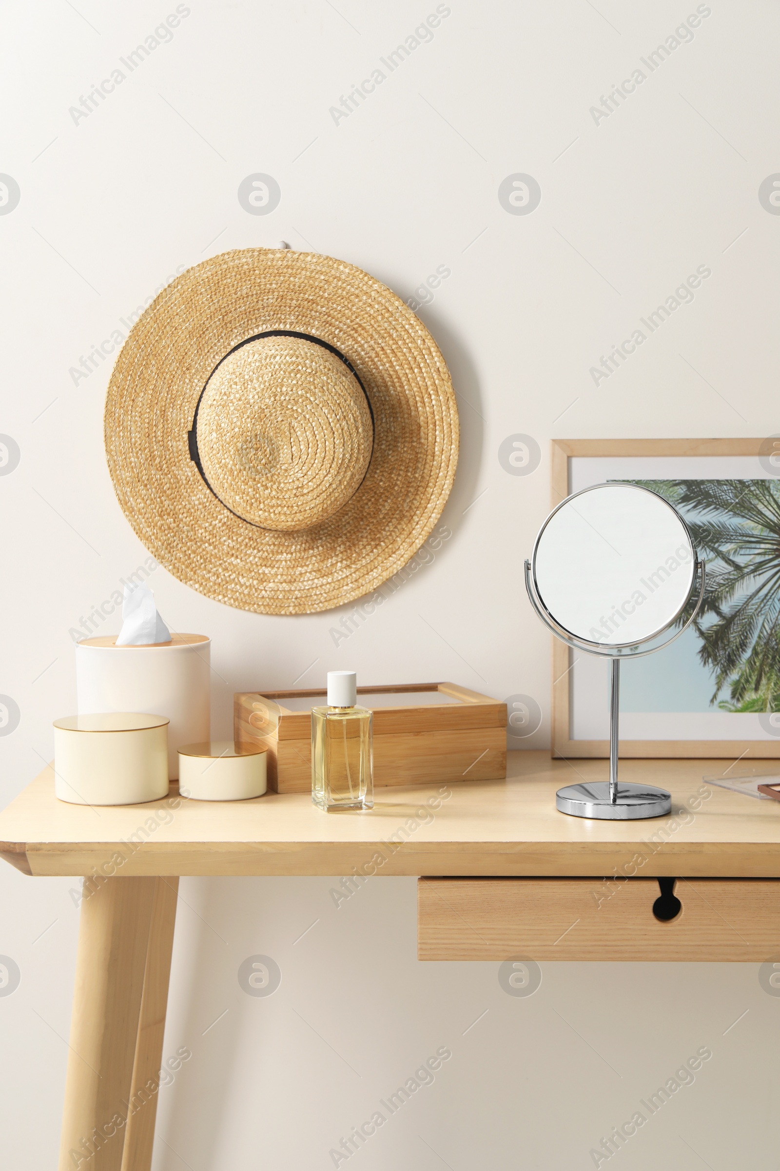 Photo of Makeup table with mirror, perfume and accessories in room