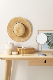 Makeup table with mirror, perfume and accessories in room