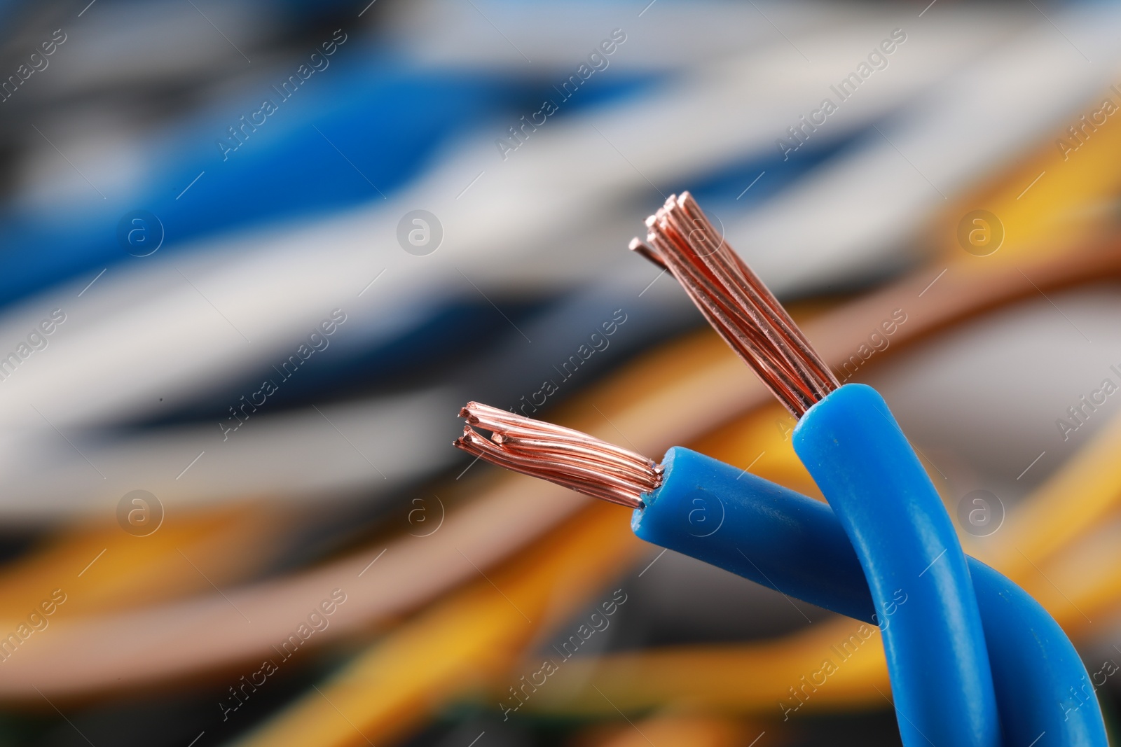 Photo of Light blue electrical wire on blurred background, closeup. Space for text