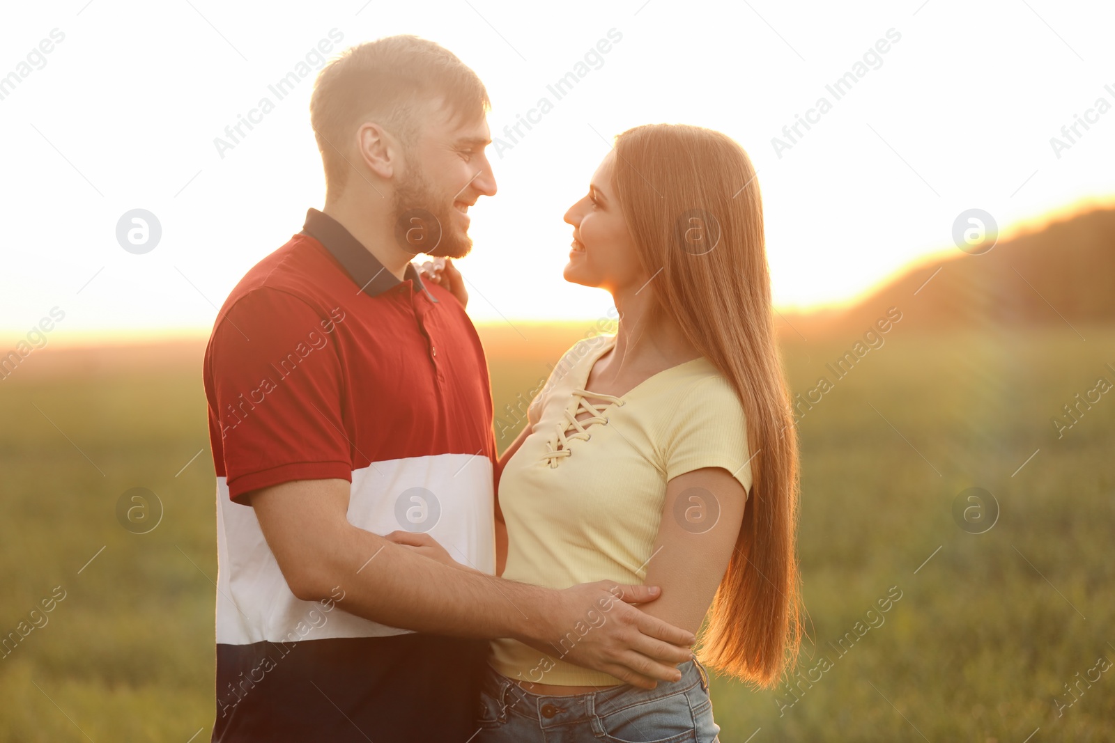 Photo of Happy young couple in green field on sunny spring day