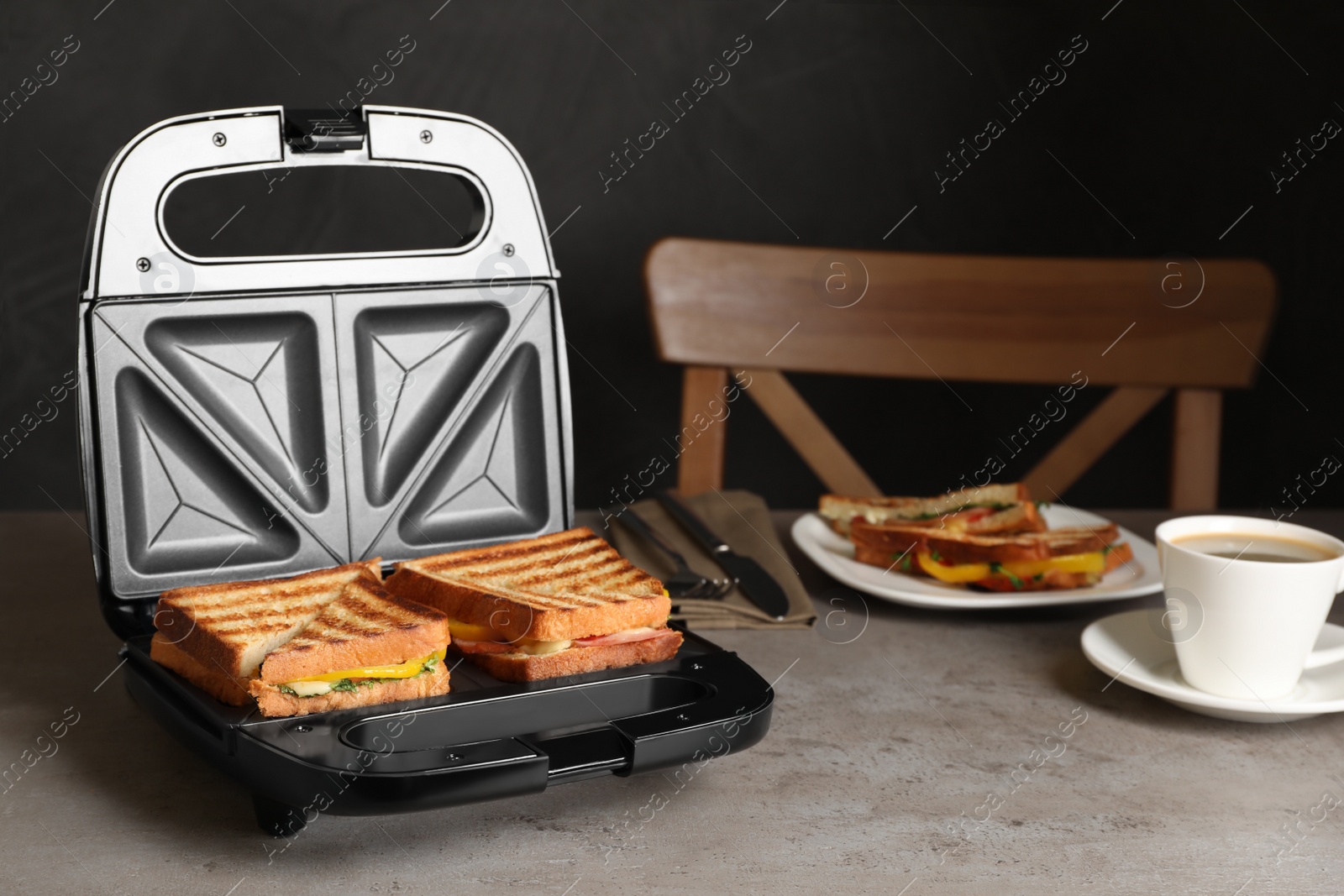 Photo of Modern grill maker with tasty sandwiches and cup of coffee on light grey table